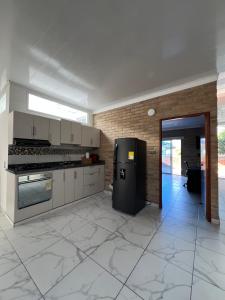 eine Küche mit einem schwarzen Kühlschrank im Zimmer in der Unterkunft The Cayetano House in Cali