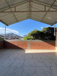 eine leere Terrasse mit einer Ziegelmauer und einem Dach in der Unterkunft The Cayetano House in Cali