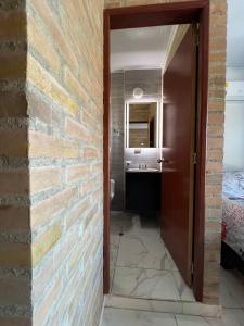 Zimmer mit Ziegelwand und Bad in der Unterkunft The Cayetano House in Cali