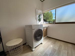 a laundry room with a washing machine and a window at 天然プラネタリウムcottage星空E棟 in Anazawa +6 photos