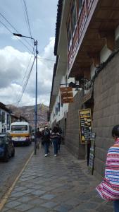 a group of people walking down a street with a bus at The heart of Tawa Wawa Wasi in Cusco