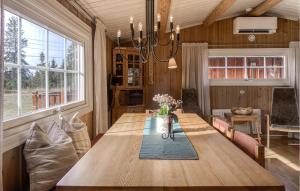 ein Esszimmer mit einem Holztisch mit Blumen darauf in der Unterkunft Cozy Home In Sjusjøen in Sjusjøen
