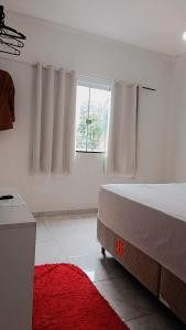 a white bedroom with a bed and a window at Família Freitas in Ananindeua +3 photos