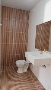 a bathroom with a white toilet and a sink at Família Freitas in Ananindeua