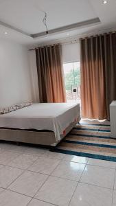 a bedroom with a bed and a large window at Família Freitas in Ananindeua