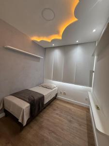 a bedroom with a bed and a ceiling with lights at Alto padrão com ar, garagem, sacada integrada in Belém +6 photos