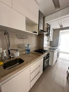 a kitchen with a sink and a counter top at Alto padrão com ar, garagem, sacada integrada in Belém
