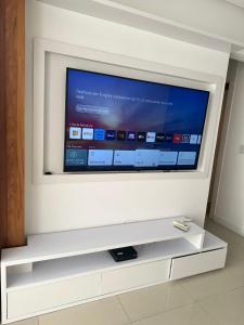 a flat screen tv sitting on a wall at Alto padrão com ar, garagem, sacada integrada in Belém