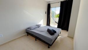 a small bed in a room with a window at Duplex em Itaúna 4min da Praia que ocorre o WSL, 1min da pista de skate do LS, pracinha com parque infantil, quadra de futebol, tudo isso a 1 min da duplex, perto do comércio, wi-fi super rápido, estacionamento gratuito, monitoramento 24hrs in Saquarema