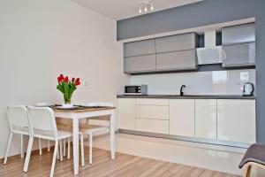 a kitchen and dining room with a table and chairs at Apartament Malva in Władysławowo