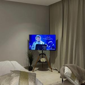 een flatscreen-tv op een stand in een slaapkamer bij Smouha in Amman +8 foto's