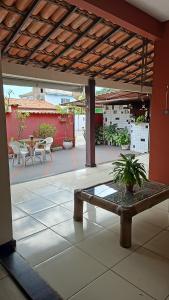 a patio with a bench and tables on a patio at Guest House Flor de Laranjeira in São Pedro da Aldeia