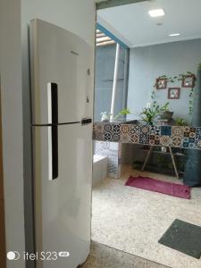 a white refrigerator in a room with a table at Casa da Josse in Camaçari