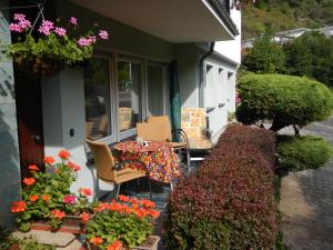 聖哥亞豪森的住宿－Ferienwohnung Späth，门廊上的桌椅,鲜花盛开