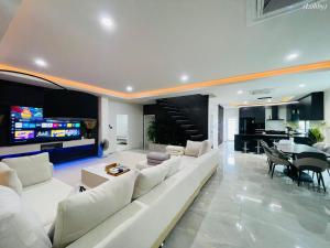 ラワイビーチにあるVilla Astra Rawai Phuketの白いソファとテレビのあるリビングルーム