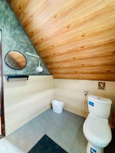 La salle de bains est pourvue de toilettes et d'un plafond en bois. dans l'établissement Arutala Villa tiitk 0 Dieng View Pegunungan, à Diyeng