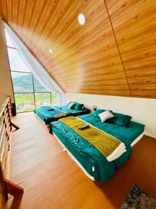 deux lits dans une chambre avec un plafond en bois dans l'établissement Arutala Villa tiitk 0 Dieng View Pegunungan, à Diyeng 16 autres photos