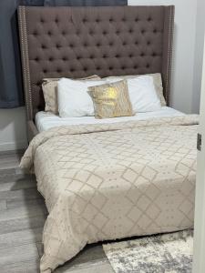 1 cama grande con cabecero acolchado en un dormitorio en Luxury Haven by Kc & Flo, en Calgary 27 fotos más