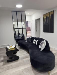 Una sala de estar con un sofá negro y una mesa. en Luxury Haven by Kc & Flo, en Calgary