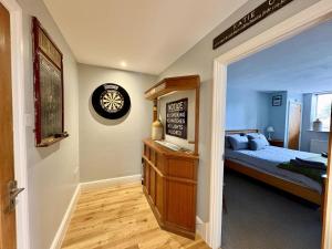Un dormitorio con una cama y un reloj en la pared. en Flat 1, Waterloo Apartments, en Radstock