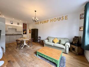 una sala de estar con un sofá y una mesa en Flat 2, Waterloo Apartments, en Radstock