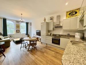 Una cocina y una sala de estar con mesa y sillas. en Flat 2, Waterloo Apartments, en Radstock