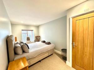 a bedroom with a bed and a wooden door at Flat 3, Waterloo Apartments in Radstock