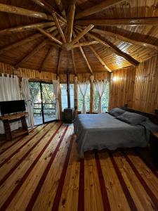 a bedroom with a bed in a wooden house at Reserva los Bollenes in Constitución +82 photos