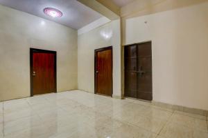 Habitación vacía con 3 puertas y suelo de baldosa. en OYO 90856 HOTEL MANNAT, en Aligarh