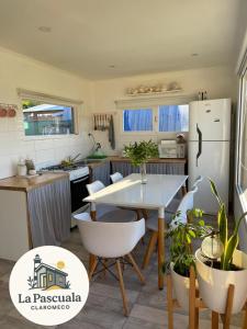 a kitchen with a table and a white refrigerator at La Pascuala in Balneario Claromecó