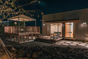 a house with a large deck at night at Fuji Private Villa FUU-KUU in Fujiyoshida +40 photos