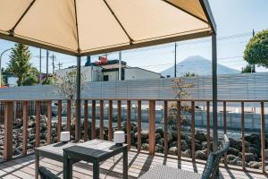 a patio with a table and an umbrella at Fuji Private Villa FUU-KUU in Fujiyoshida
