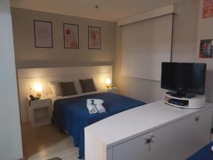 a bedroom with a bed with a television on it at Flat Wyndham2 Paulista com estacionamento in Sao Paulo