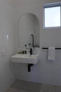 a white bathroom with a sink and a mirror at Yandina Station in Yandina Creek