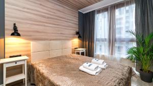 a bedroom with a bed with towels on it at Maya's Flats & Resorts 24 - Hollywood in Gdańsk