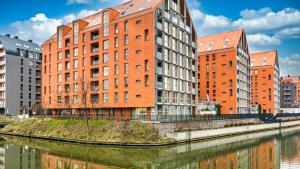 a group of buildings next to a river at Maya's Flats & Resorts 24 - Hollywood in Gdańsk