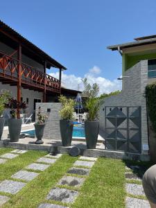 a patio with potted plants and a swimming pool at Condominium Village V Praia dos Carneiros-PE in Tamandaré