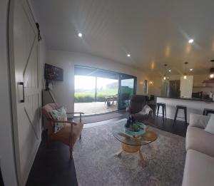 a living room with a couch and a table at Onewhero Country Cabin in Onewhero