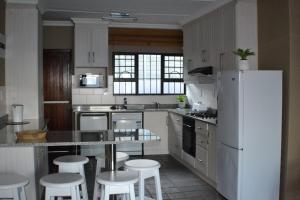 a kitchen with a white refrigerator and some white stools at Natspat 20 in Margate