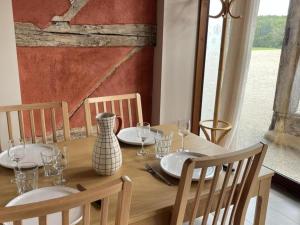 un tavolo di legno con piatti e un vaso sopra di Gîte au calme à Montbeugny, 4 pers, animaux admis - FR-1-489-597 a La Faye