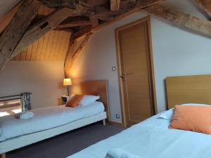 due letti in una stanza con soffitti in legno di Gîte au calme à Montbeugny, 4 pers, animaux admis - FR-1-489-597 a La Faye