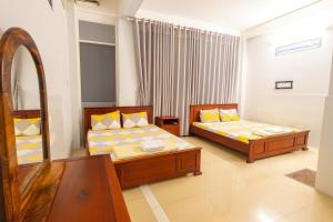 a bedroom with two beds and a mirror at Kathy Hotel in Ho Chi Minh City