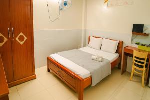 a small bedroom with a bed and a desk at Kathy Hotel in Ho Chi Minh City