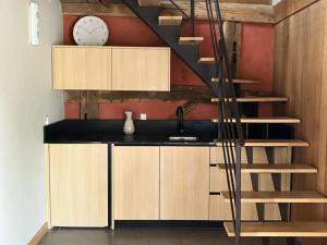 a kitchen with a staircase and a clock on the wall at Gîte La Huzarde: Havre de paix en nature, Allier - FR-1-489-599 in La Faye +8 photos