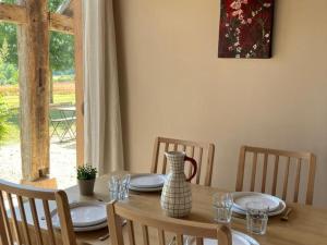 a dining room table with plates and a vase on it at Gîte La Huzarde: Havre de paix en nature, Allier - FR-1-489-599 in La Faye