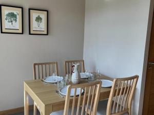 tavolo da pranzo con sedie e tavolo in legno con piatti di Gîte rustique au calme avec cheminée et jardin, 4 pers. - FR-1-489-600 a La Faye