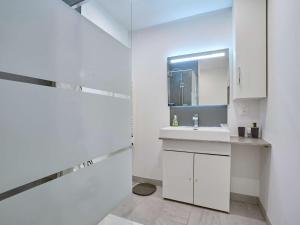 a white bathroom with a sink and a mirror at Maison T3 rénovée au cœur de Cazaubon, pour 2 à 4 pers. - FR-1-841-83 in Cazaubon