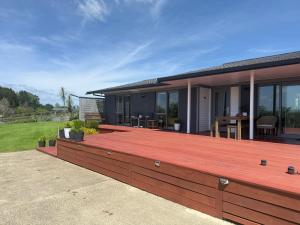 a large wooden deck on a house with a patio at B&B at whitbourne in Otorohanga