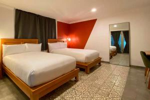 ein Hotelzimmer mit zwei Betten und einem Spiegel in der Unterkunft Hotel MX condesa CDMX, Trademark Collection by Wyndham in Mexiko-Stadt + 53 Fotos