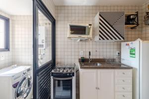 a small kitchen with a stove and a microwave at Aconchegante apartamento em Moema in Sao Paulo